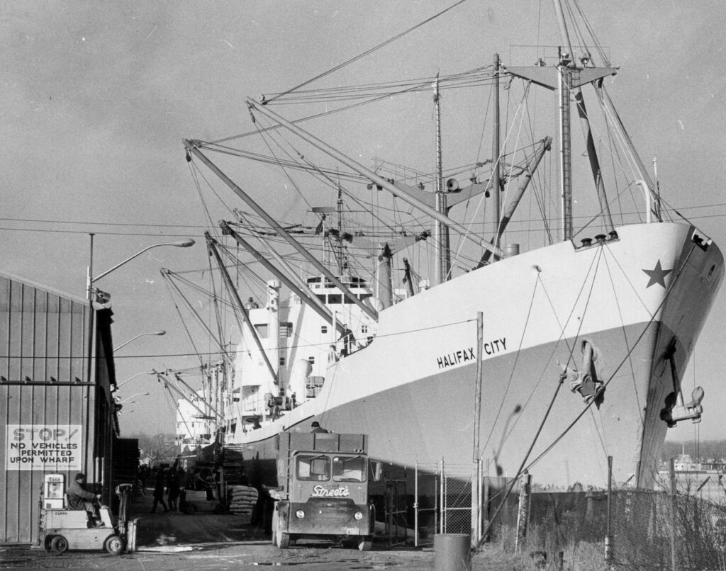 Old photo of Street Cartage truck at the docks parked in front of a cargo ship